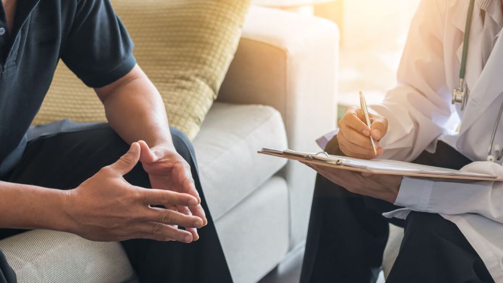 Provider taking notes while consulting with a patient
